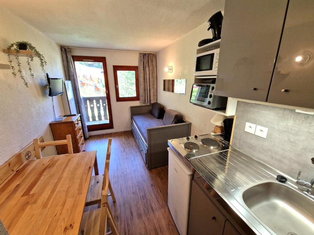 une cuisine et un salon avec un évier et une table dans l'établissement Studio rénové 2-3 personnes à Valfréjus, balcon et vue piste - FR-1-265-229, à Valfréjus