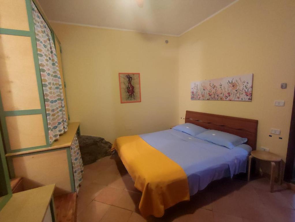 sypialnia z łóżkiem z niebieską i żółtą pościelą w obiekcie Casa Lucilla w mieście Pizzo