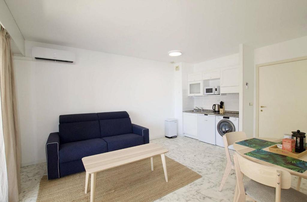 un salon avec un canapé bleu et une table dans l'établissement Beautiful apartment with Sea View / 21, à Beausoleil