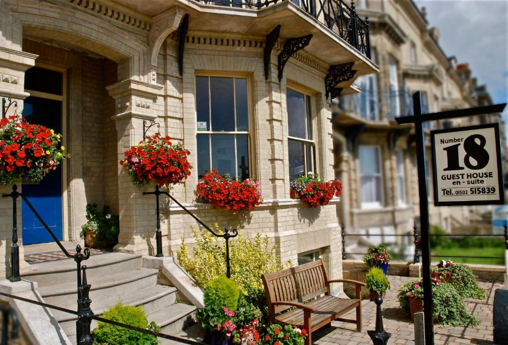 una casa con vasi di fiori e una panchina di fronte ad essa di No.18 a Lowestoft