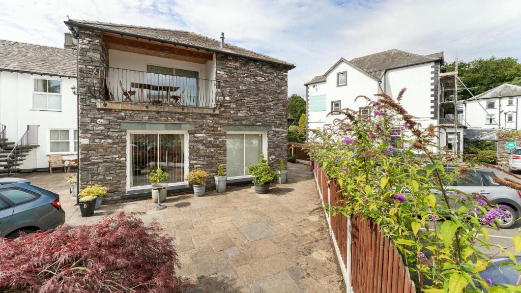 a brick house with a fence and some plants at Derwentwater View in Portinscale