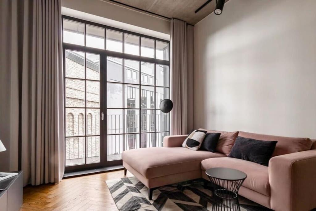 a living room with a couch and a large window at Luxury loft in central Tallinn in Tallinn
