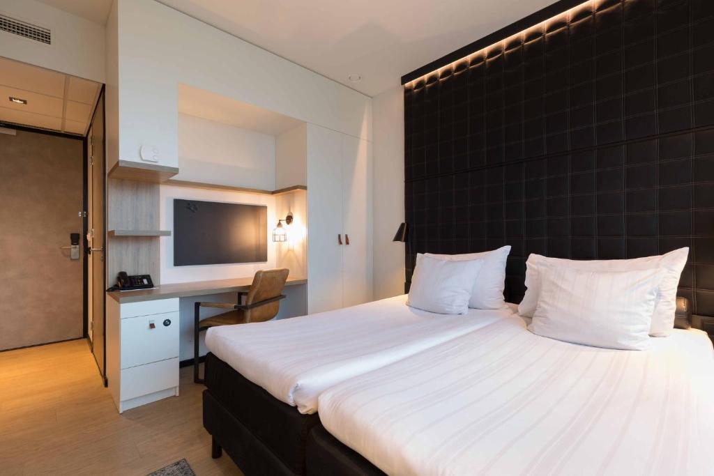 Postel nebo postele na pokoji v ubytování Leonardo Hotel Groningen