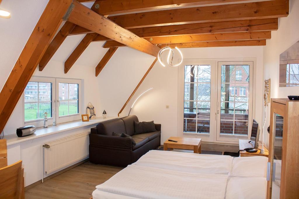 a living room with a bed and a couch at Appartement Achtern Diek 2-23 in Dorum-Neufeld