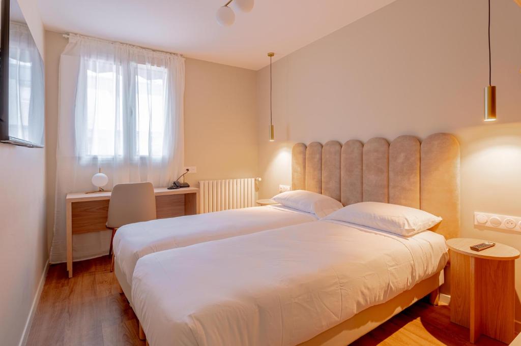 a hotel room with two beds and a window at Grand Hotel Sénia - Paris Orly Airport in Orly