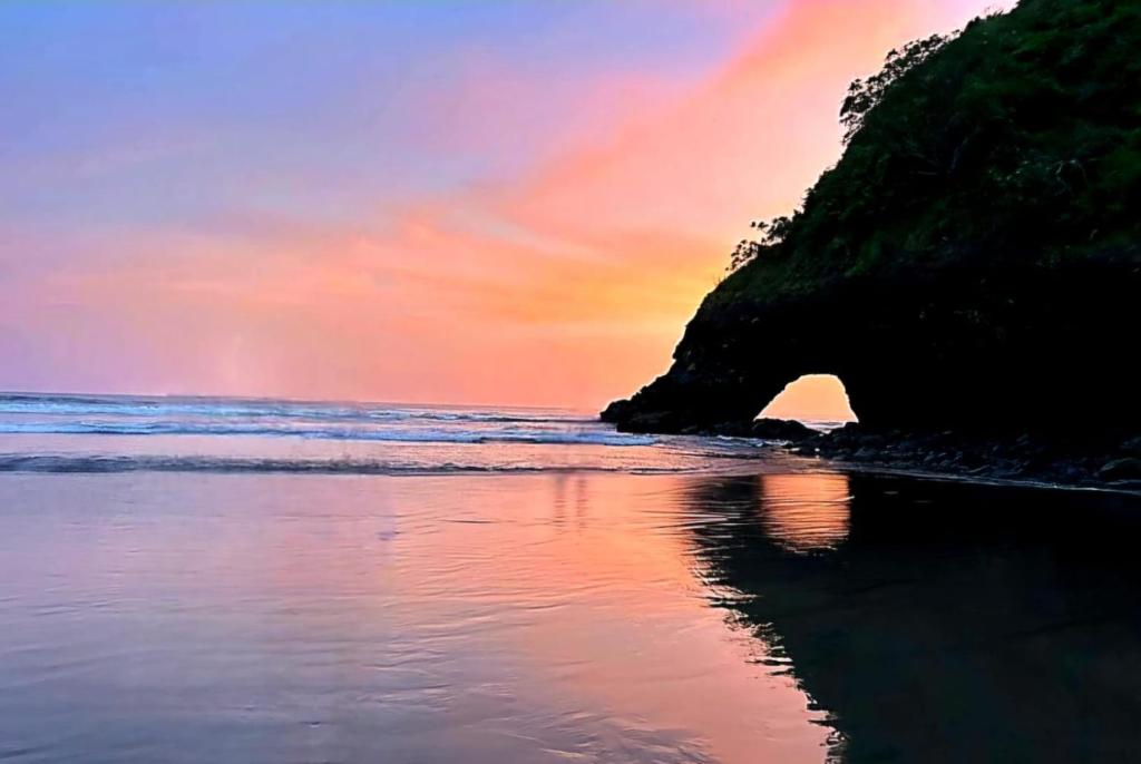 a sunset on the beach with a rainbow in the sky at Bella Vista Hotel Boutique in San Miguel