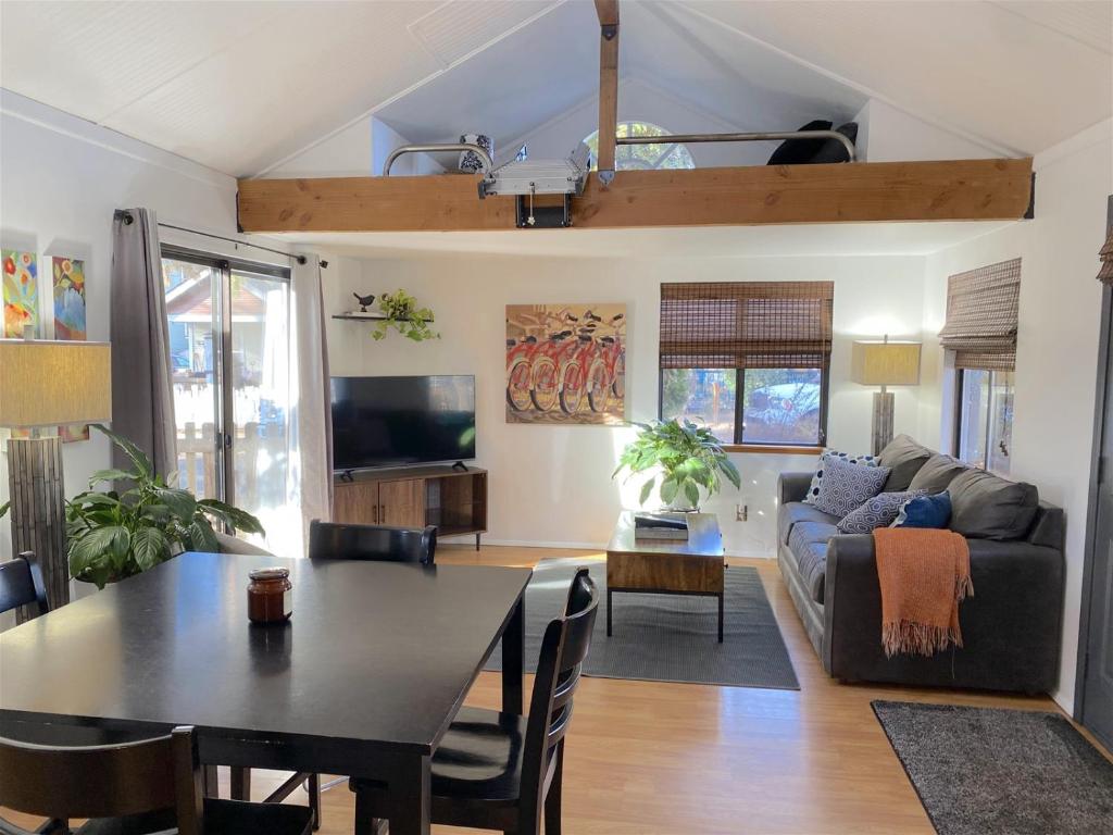 a living room with a table and a couch at Bluebird Day - River Gem Bungalow in Bend