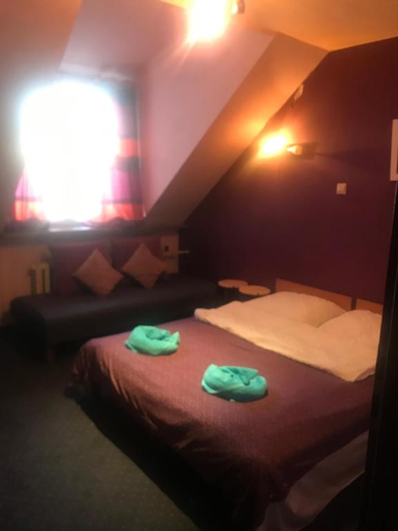 Forum noclegi kwatery pracownicze في لودز: غرفة فندق عليها سرير وفوط خضراء