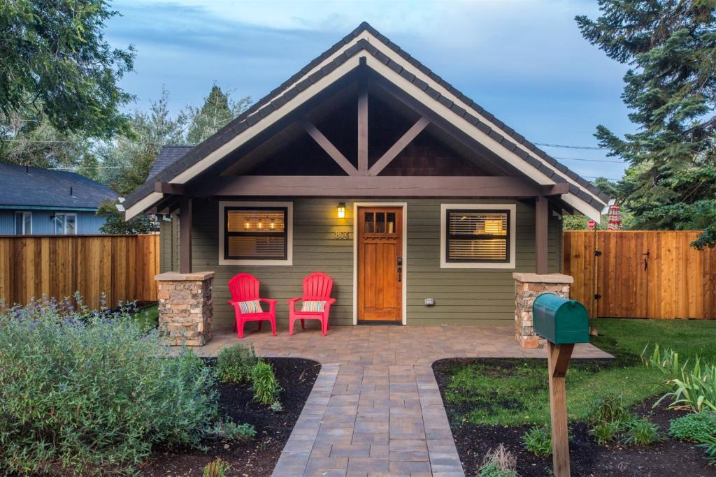ベンドにあるBluebird Day - Deschutes Bungalowの小さな緑の家とその前に2脚の赤い椅子