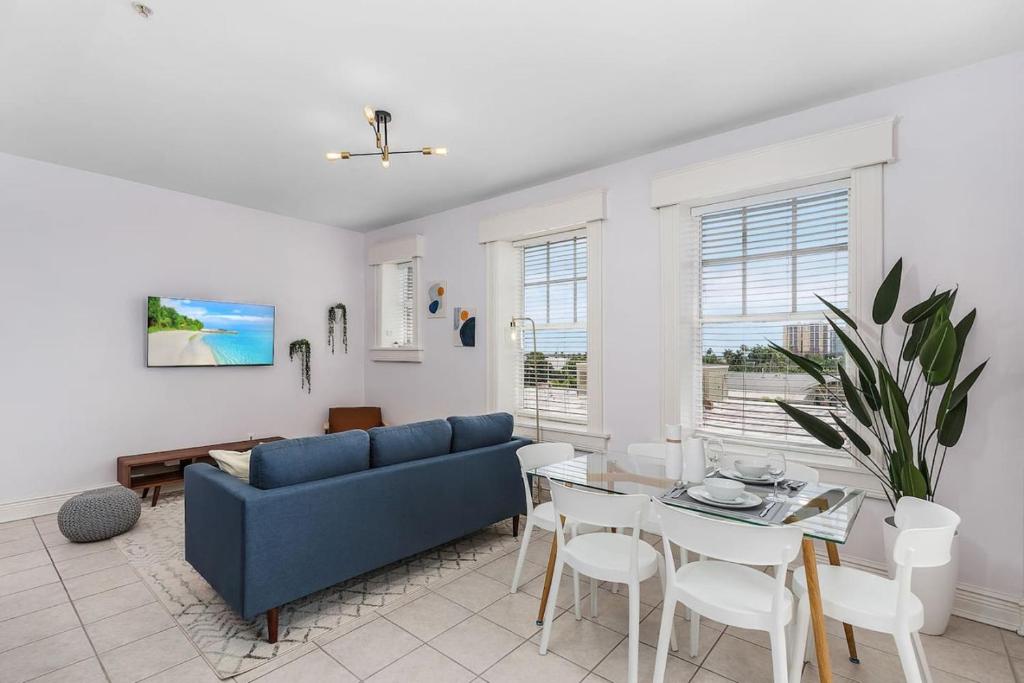 a living room with a blue couch and a table at Casa Palma Historic apt in the BEST spot downtown in Fort Myers