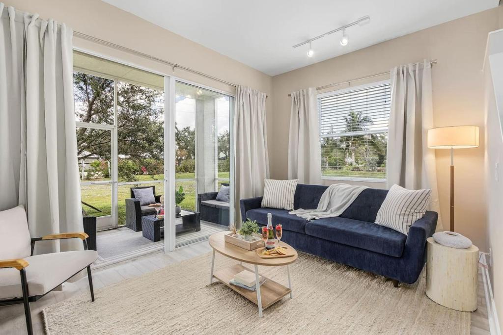 a living room with a blue couch and a table at Gorgeous Townhome Close to the beaches in Fort Myers