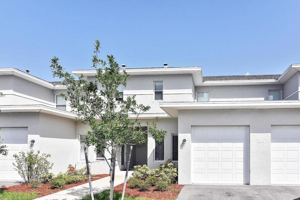 a large white house with a garage at Modern Townhouse close to beaches in Fort Myers