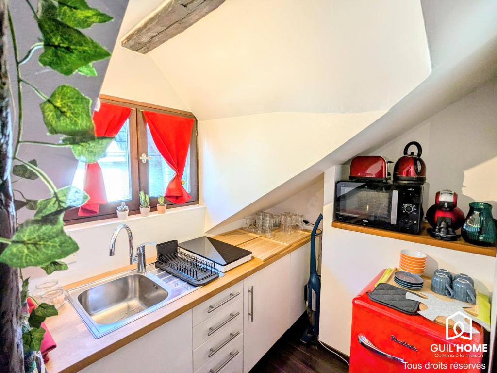 une cuisine avec un évier et un plan de travail dans l'établissement Ô Cocon - Central - Climatisé - Poutres apparentes, à Orléans