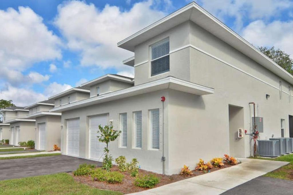 a white house with a driveway at Hideaway at Hidden Palms Cove in Fort Myers