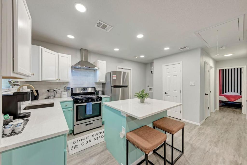 a kitchen with white cabinets and a stove top oven at Pink Fun Home - Minutes to Downtown-AUS in Austin