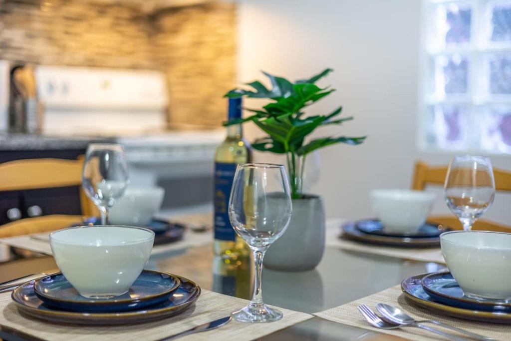 a table with glasses and plates and a bottle of wine at Bright 1BR Apt with Niagara Falls and Scenic Stay in Niagara Falls