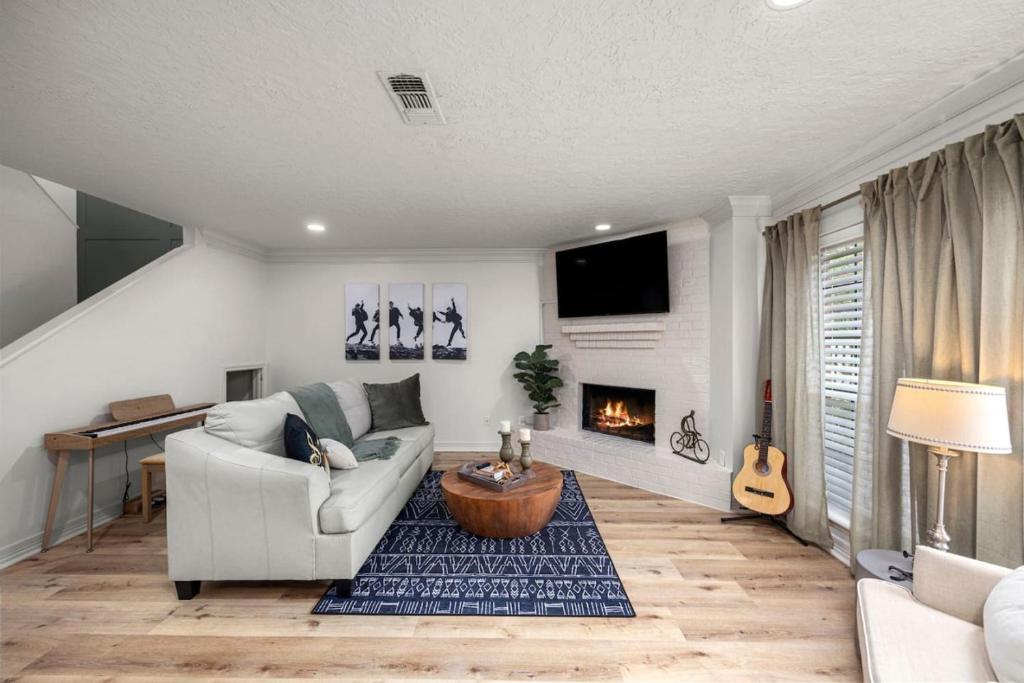 a living room with a couch and a fireplace at Walkable Montrose 2BR Music Retreat Sleeps 10 in Houston