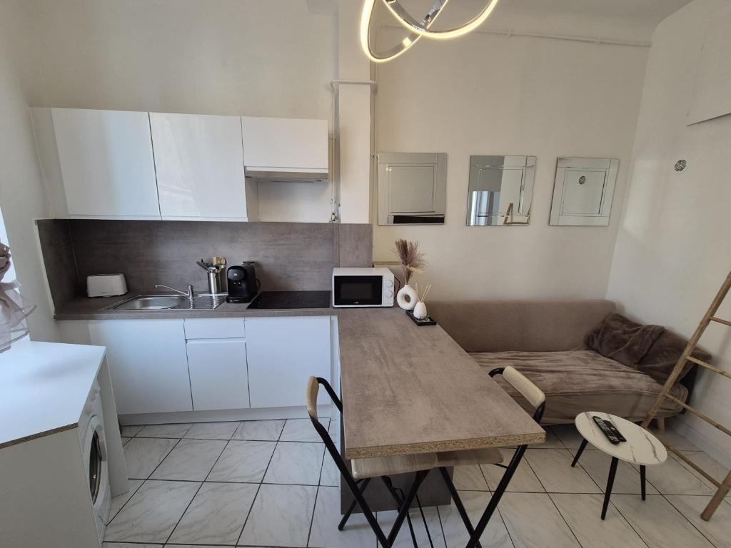 une cuisine et un salon avec une table et un canapé dans l'établissement cosy t-3 proche velodrome,plages idéalement situé, à Marseille