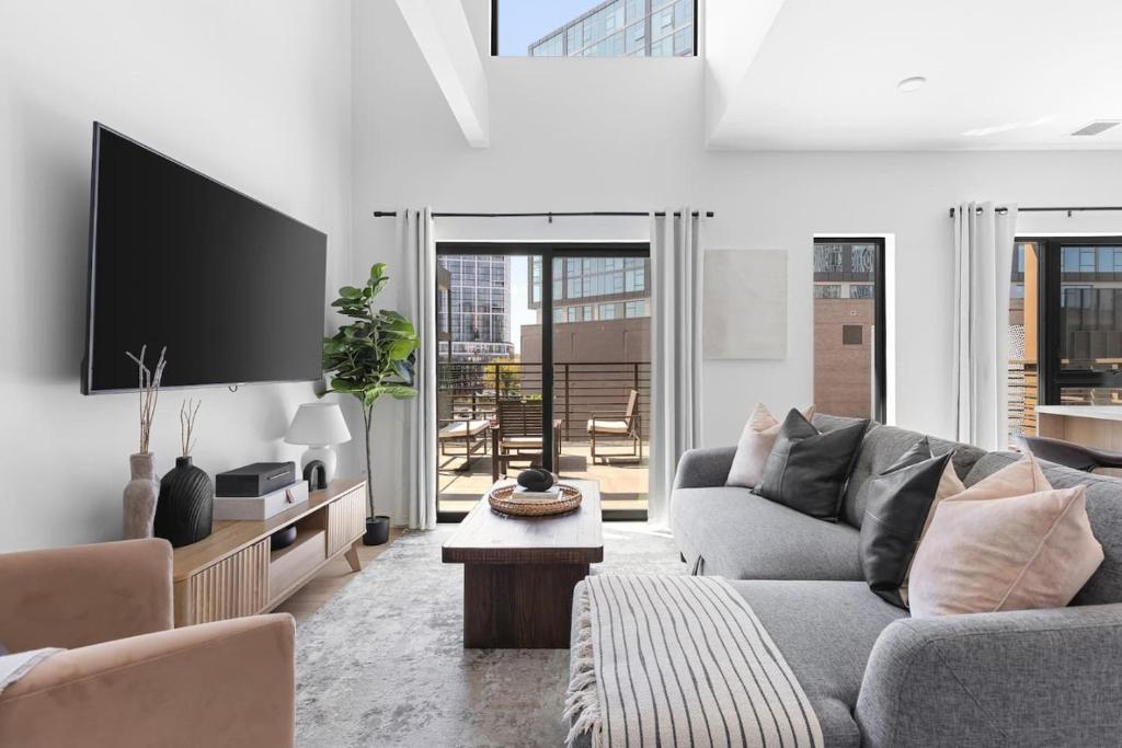 a living room with a couch and a tv at Luxury Penthouse with 2 Floors Pool Patio Gym Walk to Broadway in Nashville