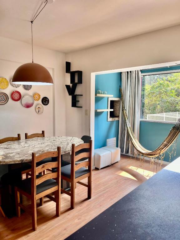 a dining room with a table and chairs at Apê da Gabi in Balneário Camboriú