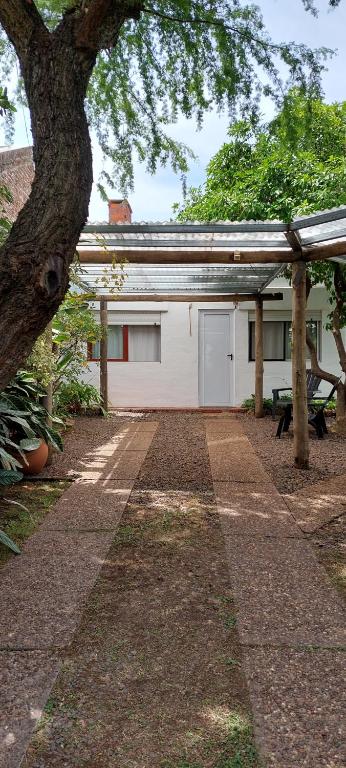 a white garage with a tree and a building at Los Picaflores in Colón