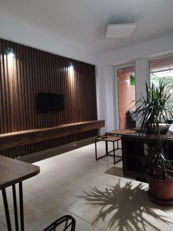 a living room with tables and a flat screen tv at Alexandria Lux Apartments in Karpoš Dva