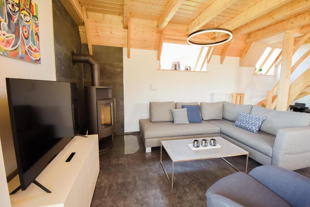 a living room with a couch and a tv at Ferienhaus Mellumplate 23 in Dorum Neufeld