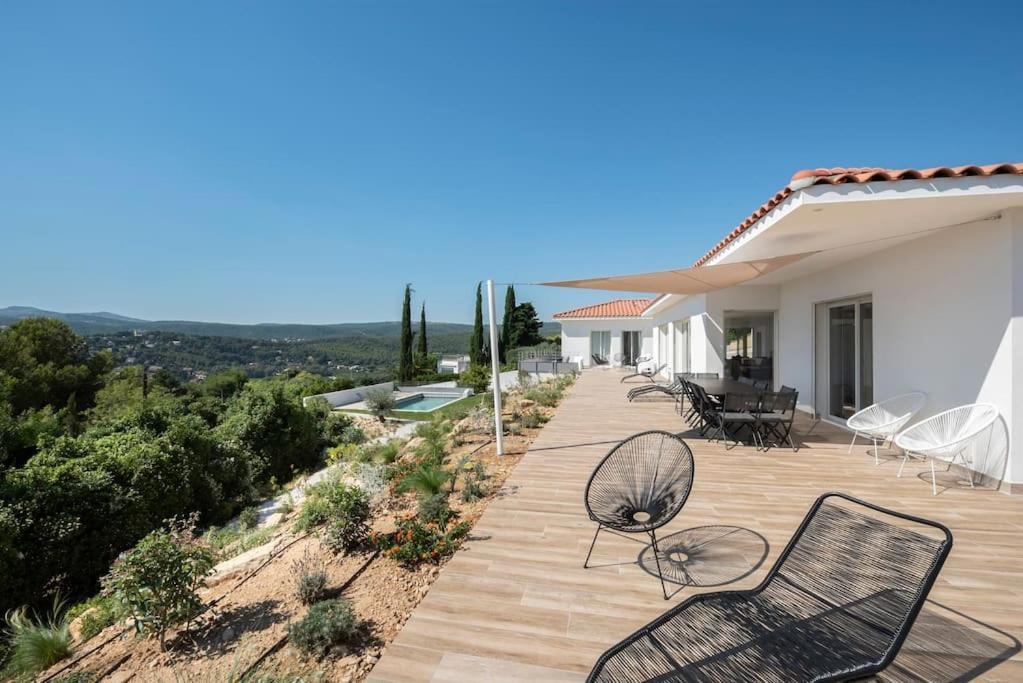 une terrasse en bois avec des chaises et une maison dans l'établissement Villa DADOU, à Cassis