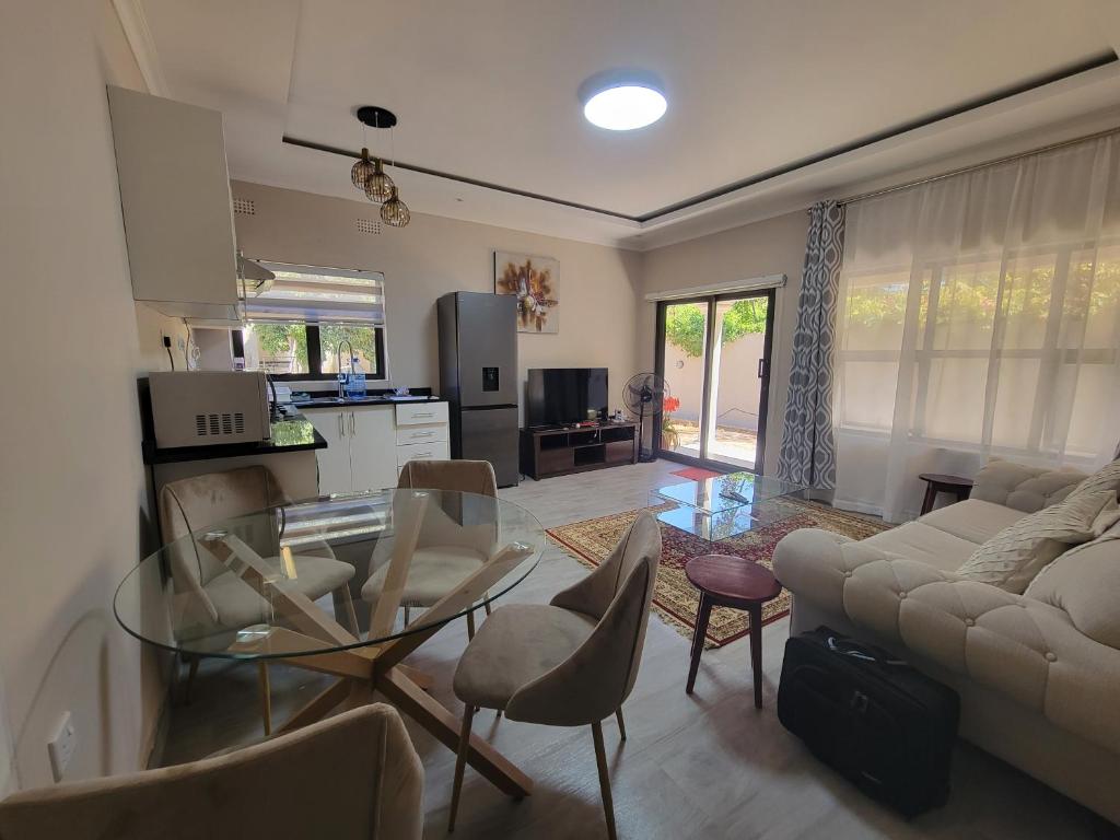 a living room with a glass table and a couch at Sable Suites C1, 1 Bed Apartments in Kabulonga in Lusaka
