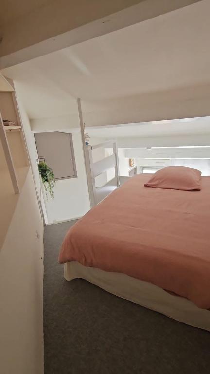 une chambre avec un lit avec une couette rouge dans l'établissement Centre ville vue St Clair, à Sète