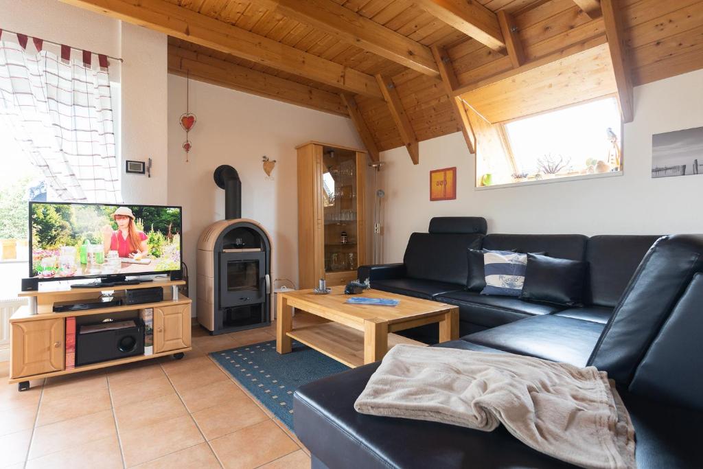 a living room with a couch and a tv at Ferienhaus "Moby Dick" Mellumplate 44 in Dorum Neufeld