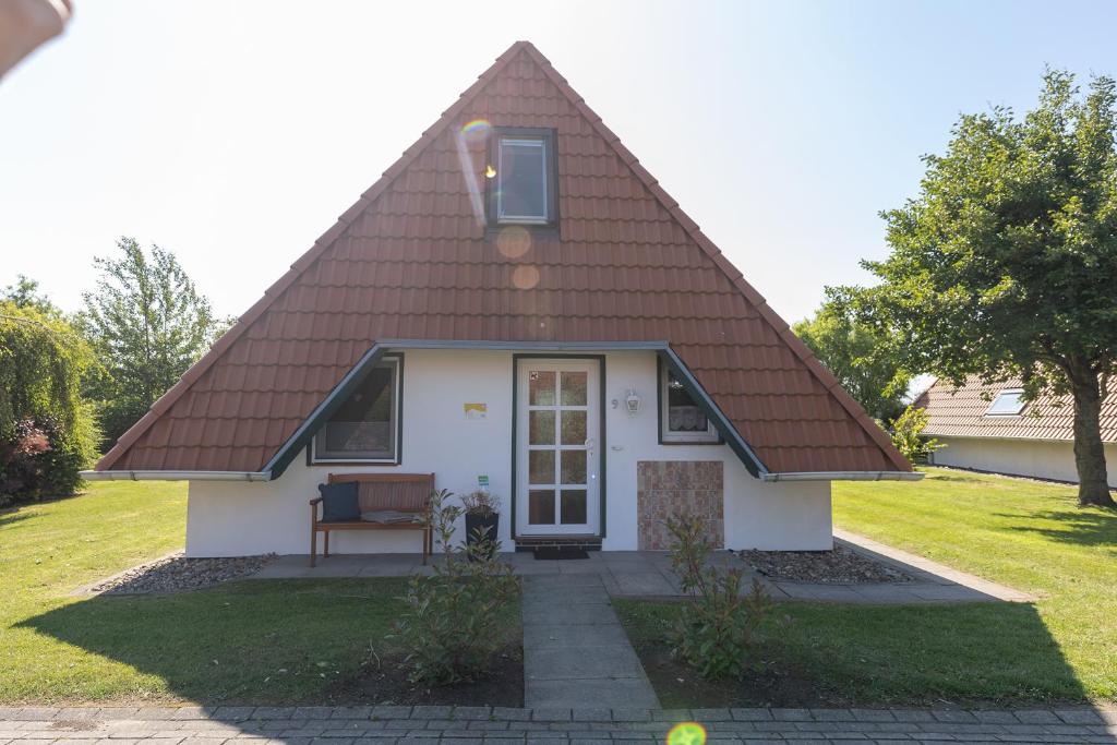 a small white house with a brown roof at Ferienhaus Hans Albers 09 in Wremen