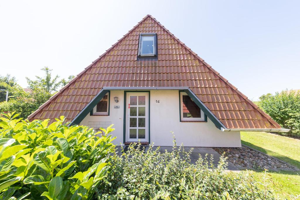 a small white house with a brown roof at Ferienhaus Hans Albers 16 in Wremen