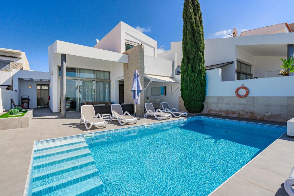 una villa con piscina frente a una casa en Villa Caterina, Luxury Villa with Heated Pool Ocean View in Adeje, Tenerife, en Adeje