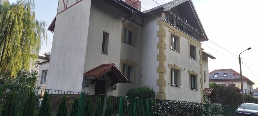 un bâtiment blanc avec une clôture devant dans l'établissement Swineminde Polen Apartament 2 person Rent bitte anrufen, à Ahlbeck