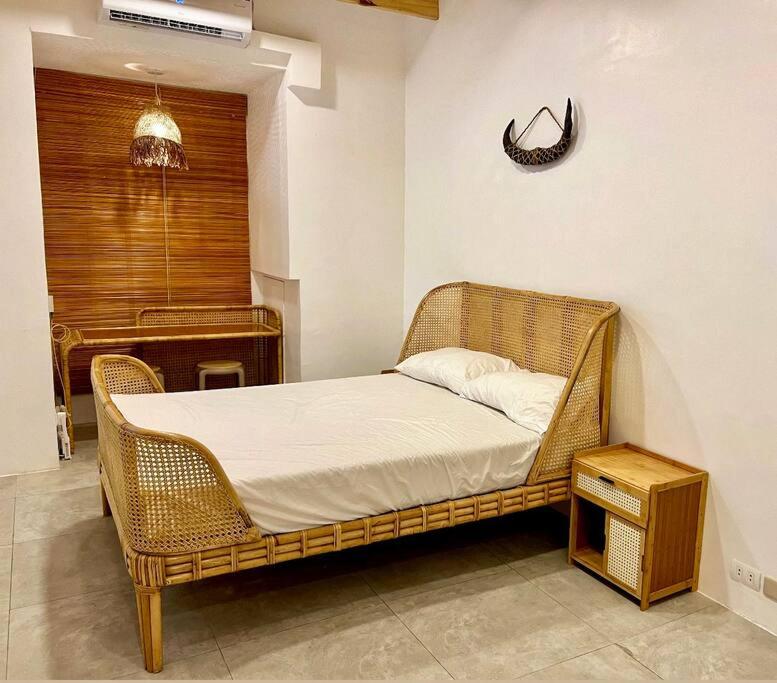 a wicker bed in a room with a piano at Bohemian Moderns Style Living- Free Pool- Pet Friendly in Manila