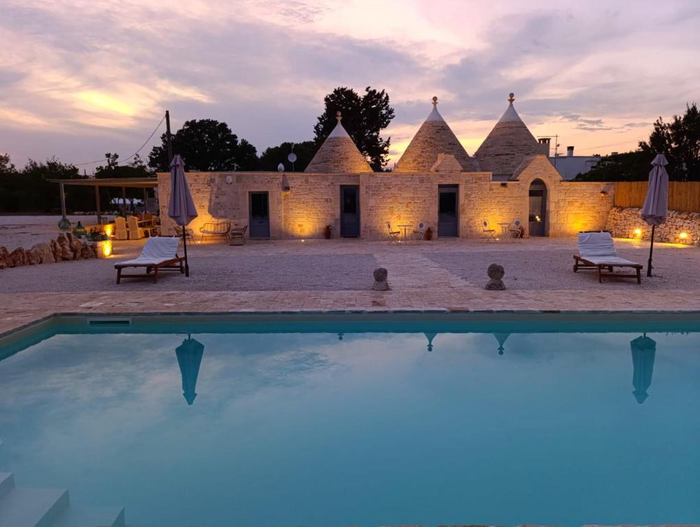 a view of a building with a pool in front of it at Trulli Fortunato private, heated swimming pool in Locorotondo
