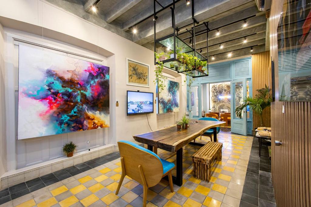 巴拿马城Casa Acomodo Casco Viejo 4bdr Historic Mansion的一间设有桌子和墙上绘画的用餐室
