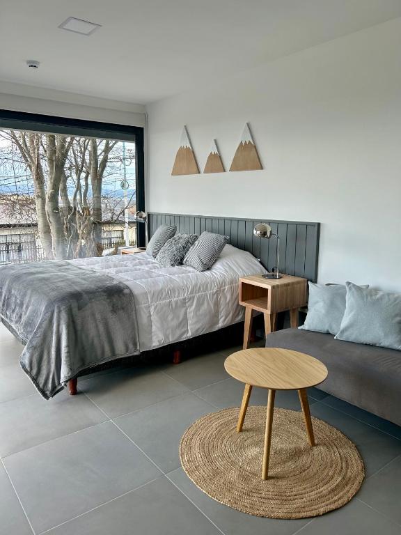 Un dormitorio con una cama, una mesa y una silla. en Penguins Flats 2, en Ushuaia