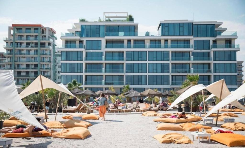 una playa con sillas y sombrillas y gente en la playa en One Mamaia Nord, en Mamaia