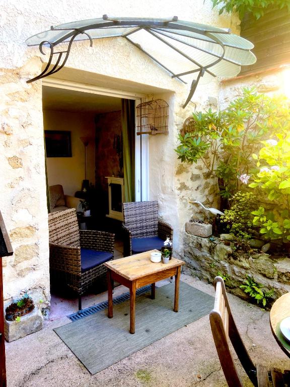 un patio avec une table et un parasol dans l'établissement Maison de charme d'Ile de France, à Chaumontel