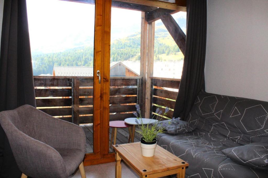 - un salon avec un canapé, une chaise et une fenêtre dans l'établissement Les Chalets De Superd Heliantheme - 2 Pièces pour 4 Personnes MAE-8704, à Saint-Étienne-en-Dévoluy