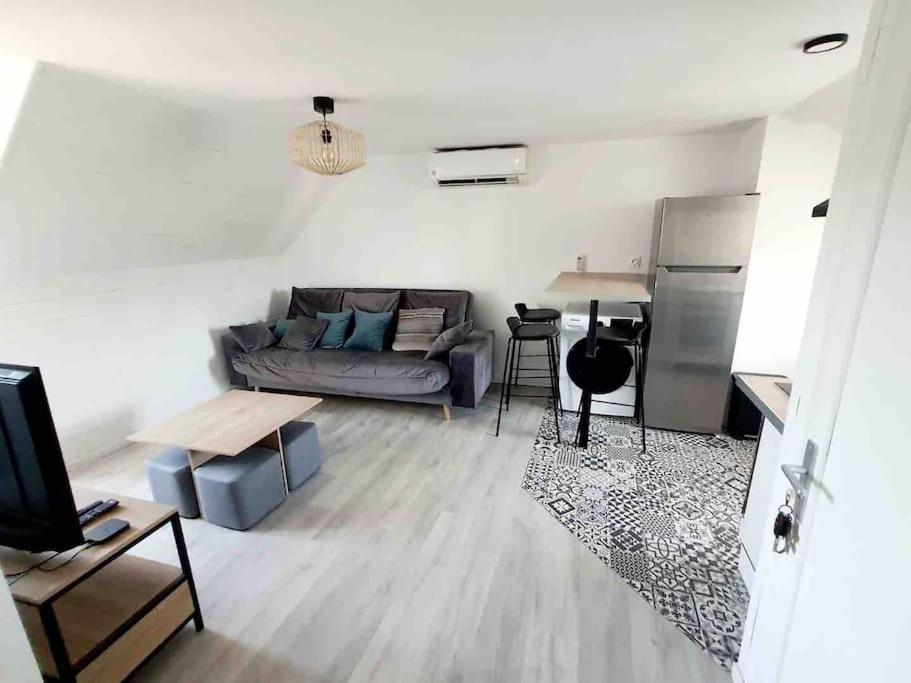 a living room with a couch and a table at jolis logements brivistes 4 in Brive-la-Gaillarde