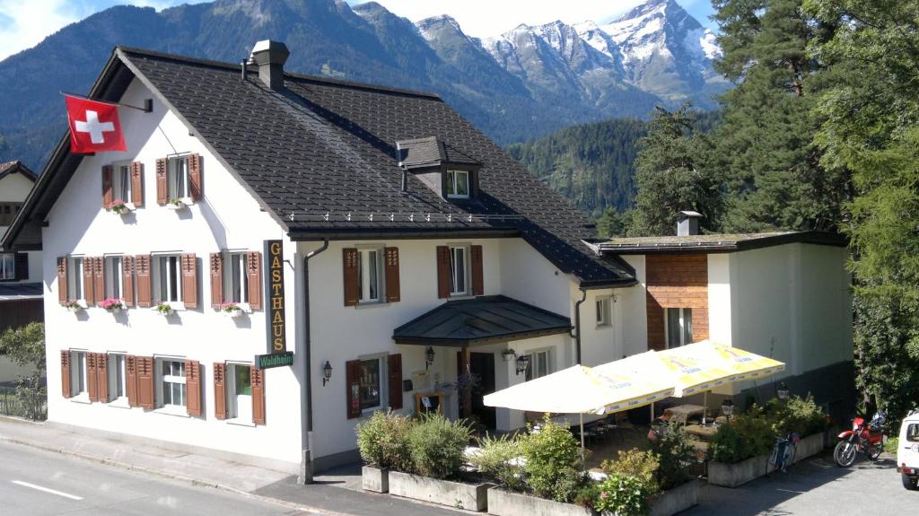 ein großes weißes Gebäude mit Bergen im Hintergrund in der Unterkunft Gasthaus Waldheim in Fürstenaubruck