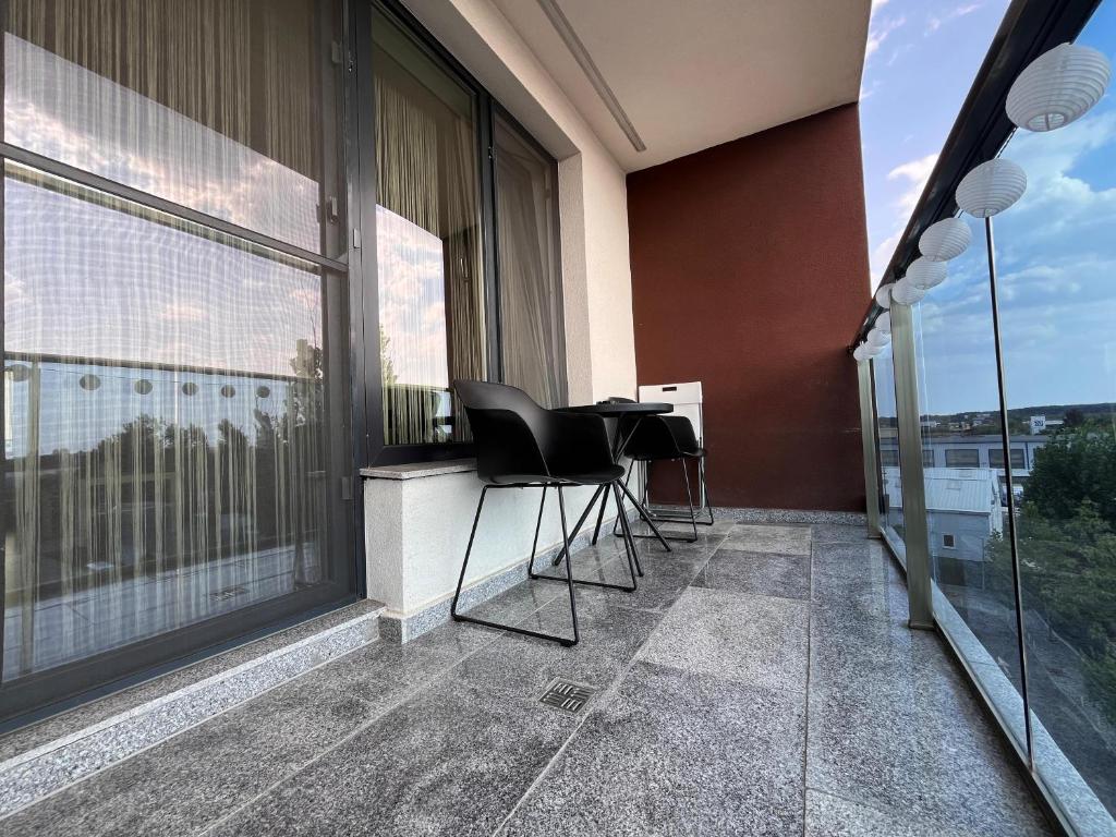 a balcony with chairs and a table on a building at Sunset Apartment Otopeni in Otopeni