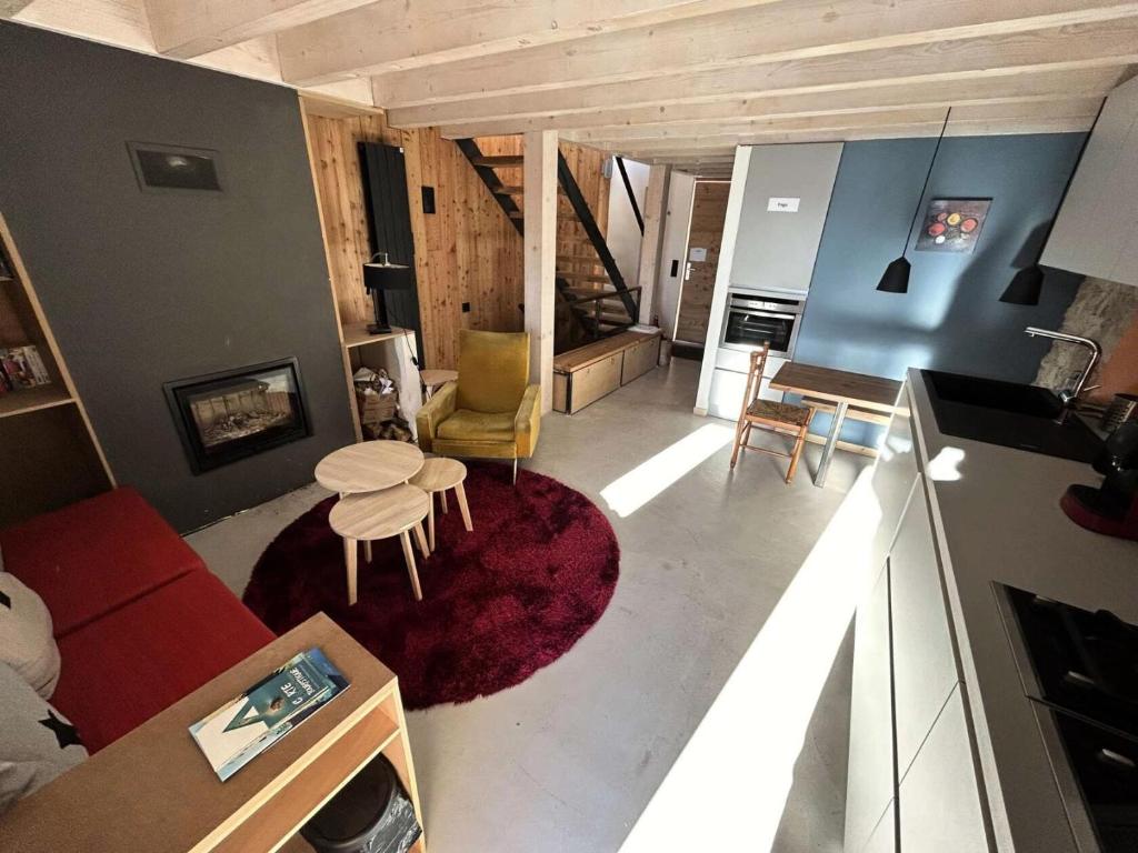 un salon avec un canapé rouge et une table dans l'établissement Résidence Means - Jolie petite maison de 3 couchages en village MEANS VILLAGE MAE-8421, à Réallon