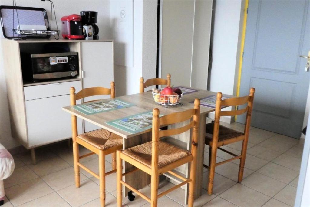 une cuisine avec une table avec des chaises et un micro-ondes dans l'établissement Résidence Gardette - Joli t2 de 4 couchages a Réallon B2 MAE-8501, à Réallon