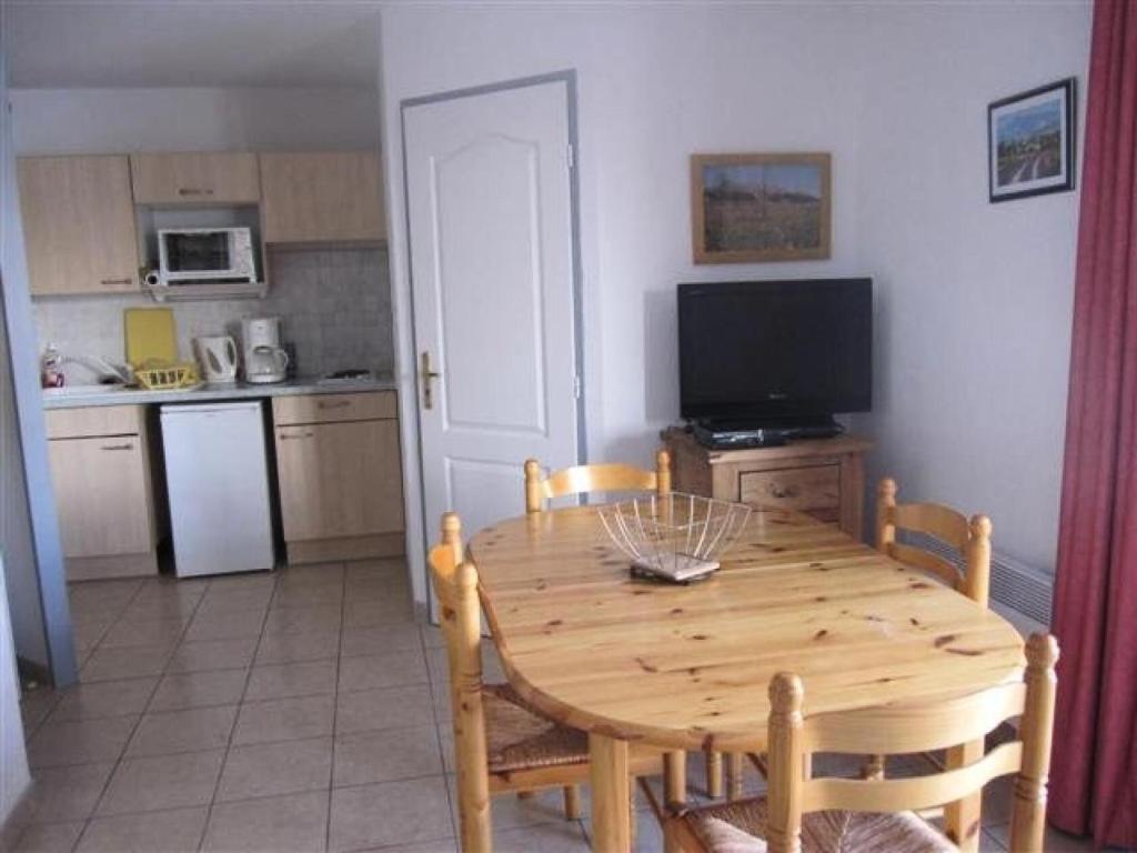 une cuisine avec une table en bois et une cuisine avec une télévision dans l'établissement Résidence Gardette - Joli t2 6 couchages sur la station de Réallon B26 MAE-8491, à Réallon