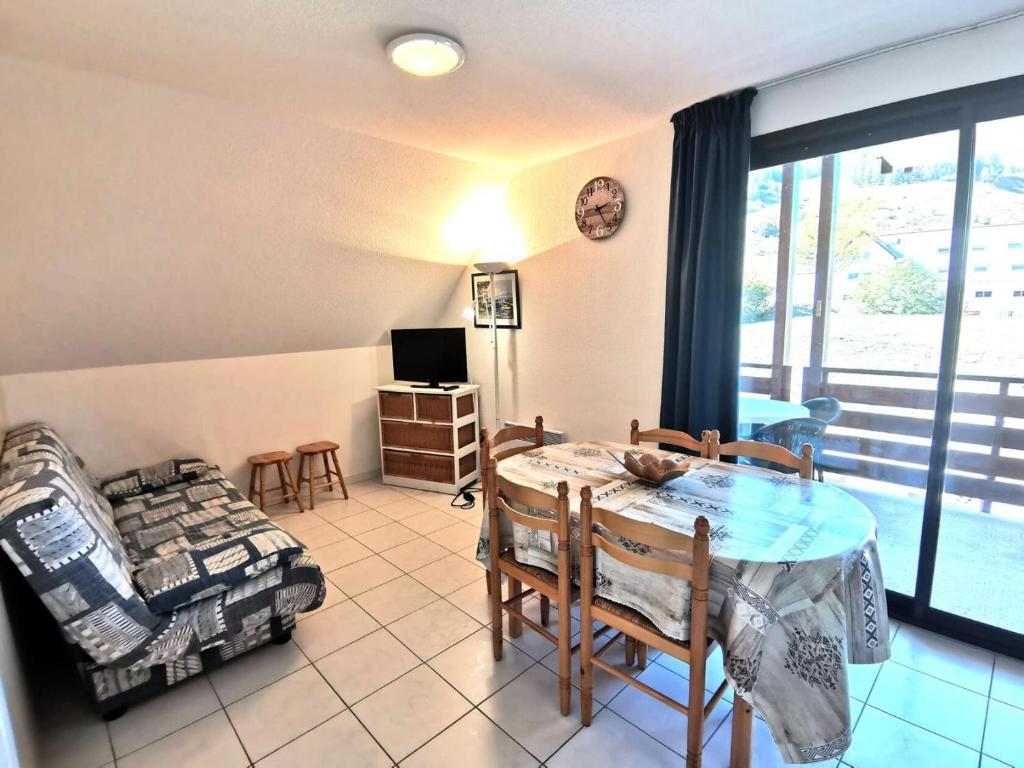 une salle à manger avec une table, des chaises et une télévision dans l'établissement Résidence Chabrieres - Très Agréable T2 pour 6 personnes à Réallon CHAB20 MAE-8751, à Réallon