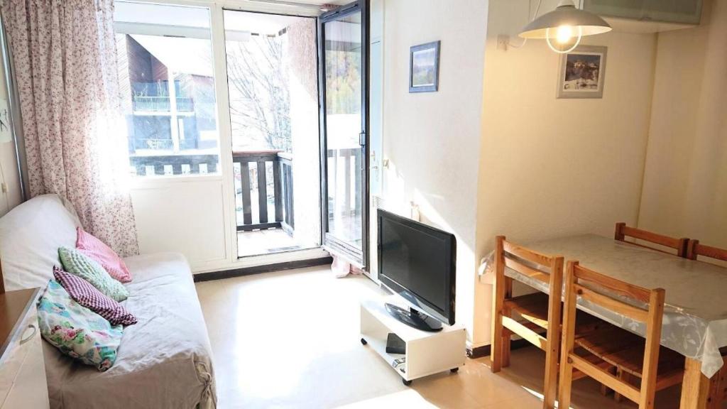 a living room with a couch and a tv and a table at Résidence Relais - Charmant T2 pour 5 personnes au cœur de la station de Réallon 243R MAE-8941 in Réallon